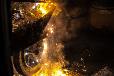 Close-up of burning coal on wheelbarrow in metal industry