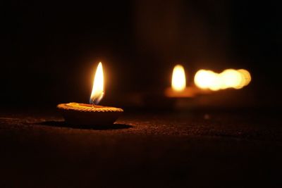 Close-up of lit candles in the dark