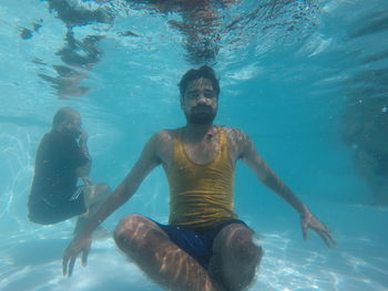 Full length of shirtless boy swimming in sea