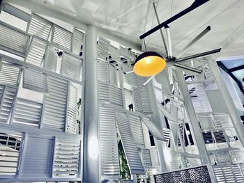 Low angle view of illuminated pendant lights hanging on ceiling in building