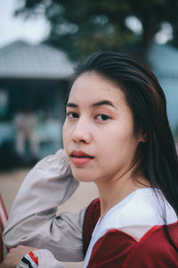 Portrait of young woman looking away outdoors