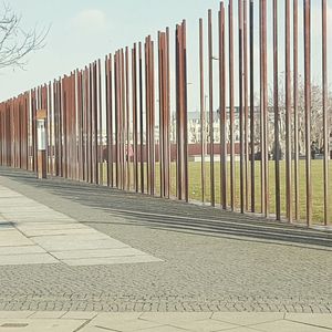 Footpath by fence against clear sky