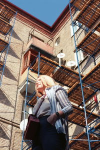 Low angle view of woman standing on staircase of building