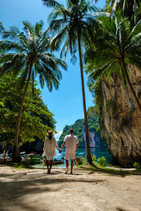 Rear view of people walking on beach