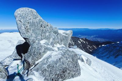 Scenic view of snowcapped mountains against blue sky