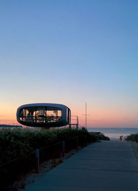 Bridge over sea against clear sky during sunset