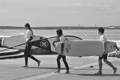 People at beach against sky