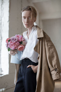 Portrait of fashionable woman with bouquet at home