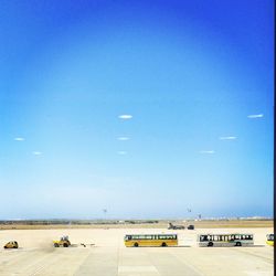 Airplane on airport runway against clear blue sky