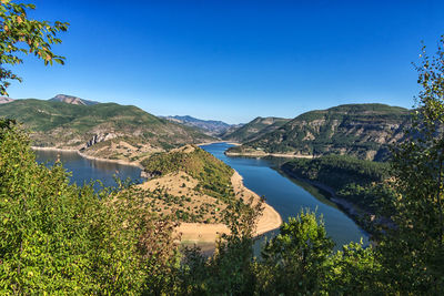 Scenic view of lake against clear blue sky