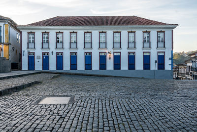 Building by street against sky in city