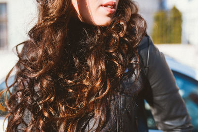 Cropped view of woman with long hair wearing leather jacket