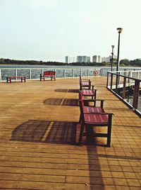 Empty chairs on beach against clear sky