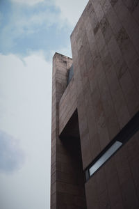 Low angle view of building against cloudy sky