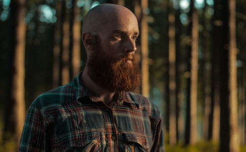 Bearded man standing in forest