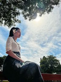 Side view of woman sitting on field