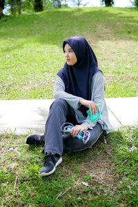 Young woman sitting on field