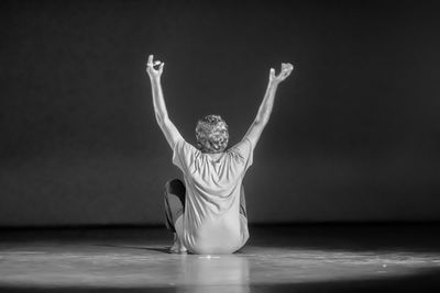 Rear view of woman doing yoga at home