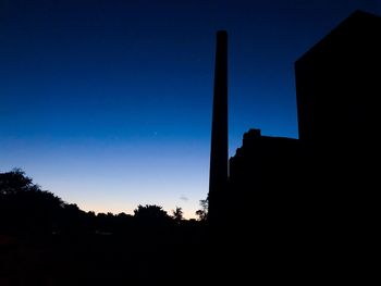 Low angle view of silhouette building against sky at night