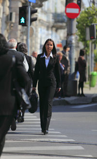 Portrait of businesswoman crossing road in city