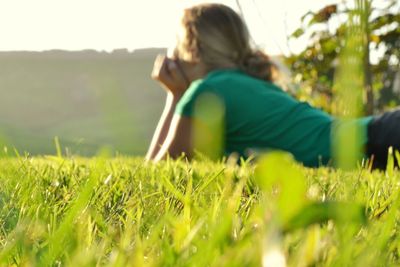 Rear view of woman sitting on field