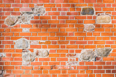Beautiful background of old vintage red or orange brick wall with stones