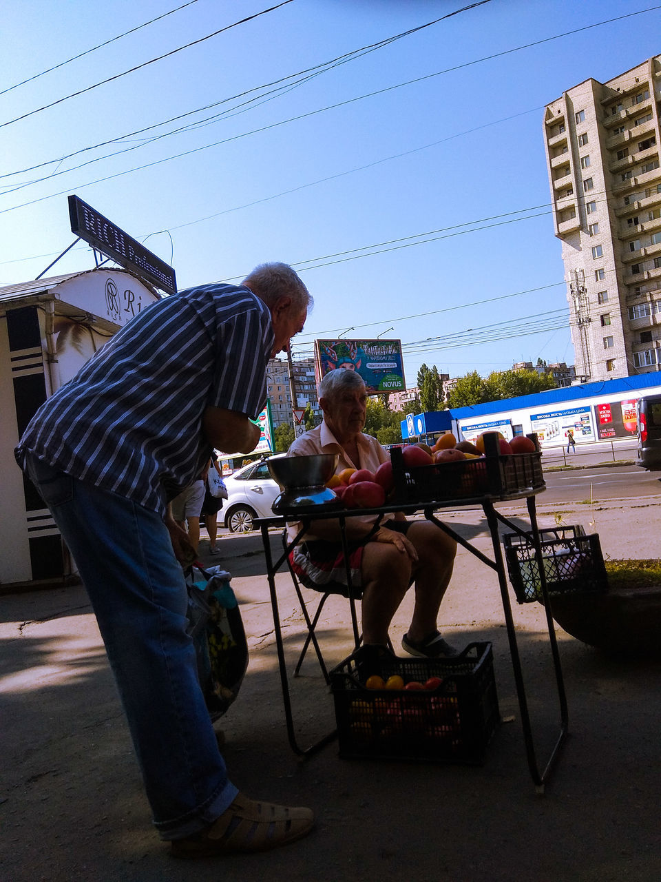 sitting, real people, full length, casual clothing, men, architecture, city, adult, lifestyles, building exterior, table, women, leisure activity, people, sky, nature, seat, day, technology, two people, outdoors, electricity, hairstyle