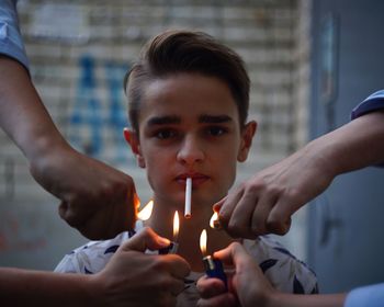 Hands igniting cigarette of teenage boy