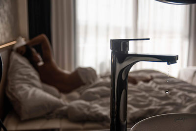 Low section of woman relaxing on bed at home