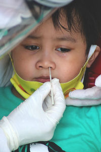 Cropped hand of doctor examining boy