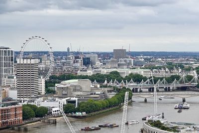 Bridge over river amidst buildings in city of london against sky