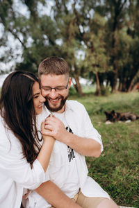 Young couple kissing against plants