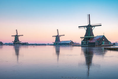 Traditional windmill against sky at sunset