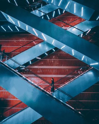 HIGH ANGLE VIEW OF PEOPLE WALKING ON MODERN STAIRCASE