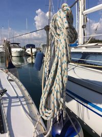 Boats moored at harbor against blue sky