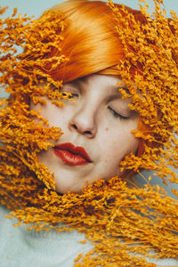 Close-up portrait of young woman with red eyes closed