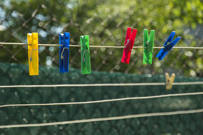 Close-up of colorful clothespin on string in back yard