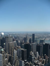 Aerial view of buildings in city against clear sky