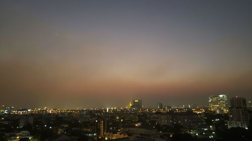 High angle view of illuminated buildings against sky at night