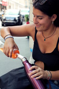 Woman pouring drink in bottle