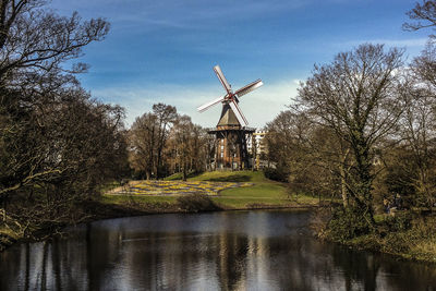 River against windmill on field