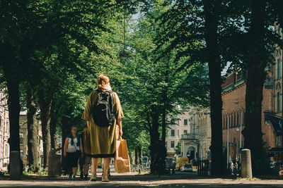 Woman standing by tree against plants