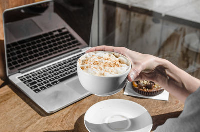 Midsection of woman having coffee