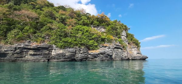 Rock formation by sea against sky