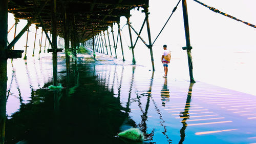 Man standing by bridge against sky