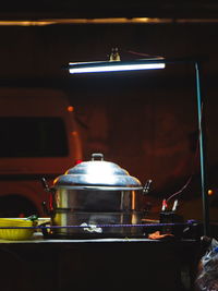 Close-up of wineglass in illuminated kitchen