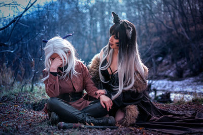 Rear view of woman sitting on rock