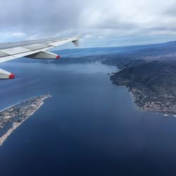 Aerial view of sea and airplane flying in sky