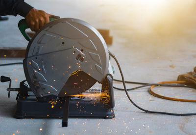 Cropped hand of worker using circular saw