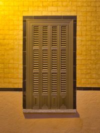 Close-up of window on yellow wall